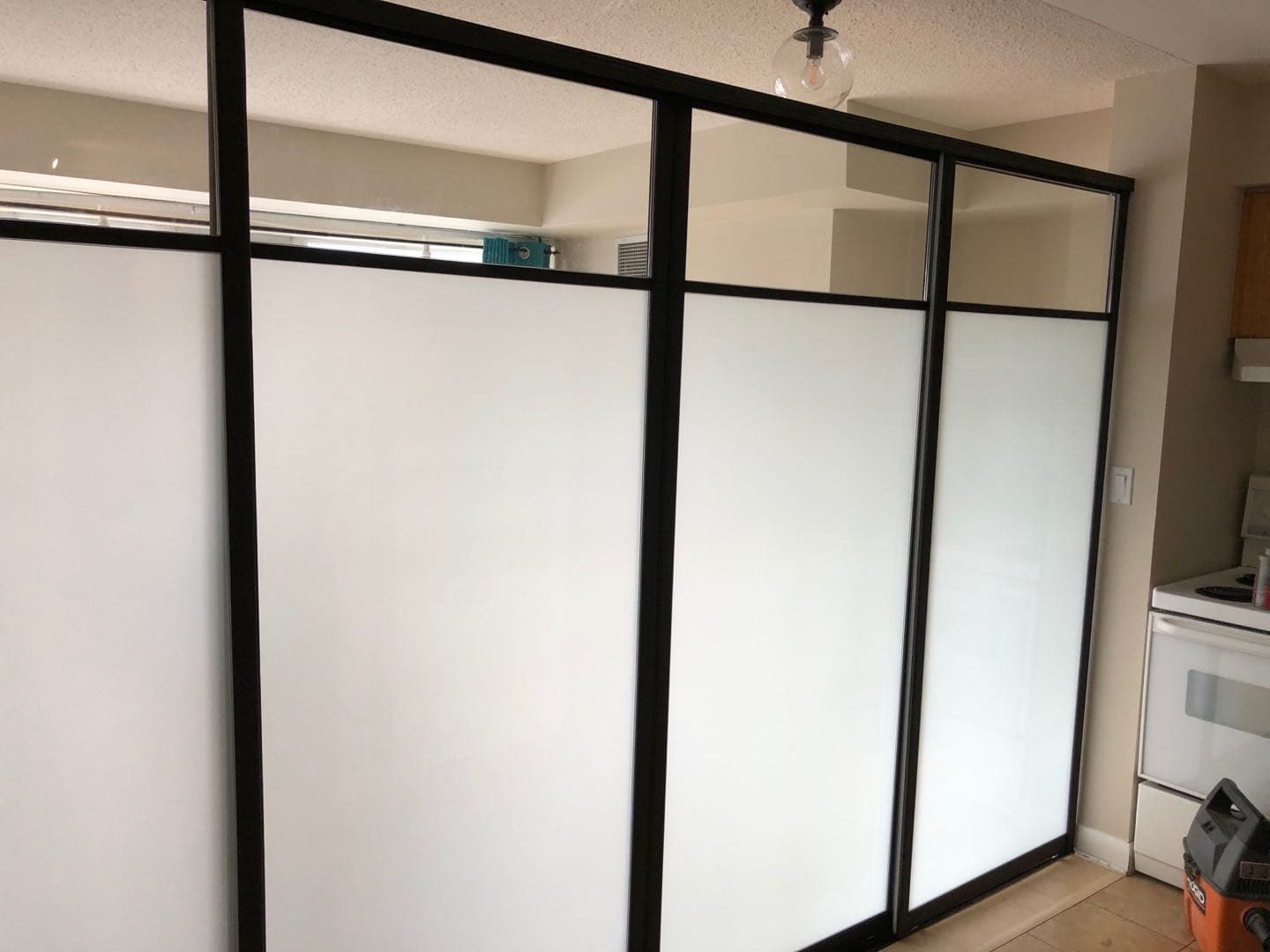 Completed Roomidea black-framed two-panel glass doors between interior rooms
