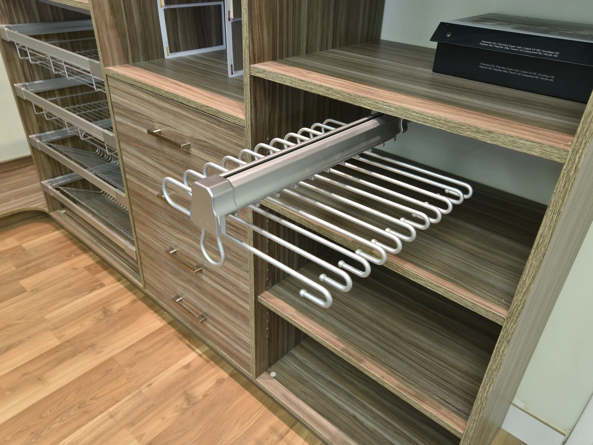 Installed pull-out hanging rack in a fitted closet display.