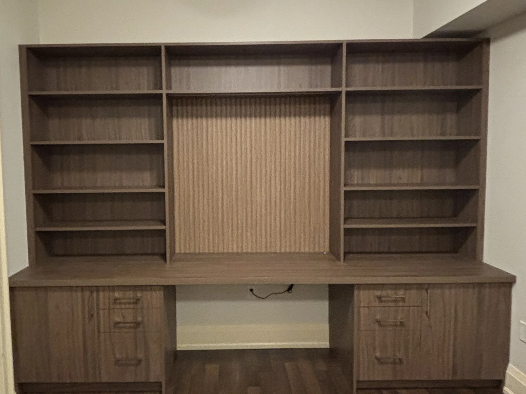 Completed dark wood home office with symmetrical shelving and base drawers.