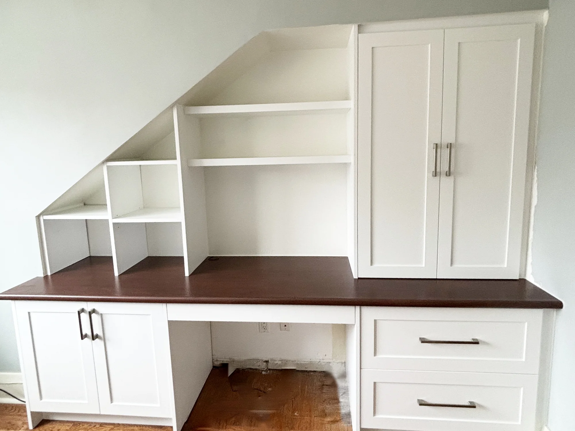 Completed fitted home office following the slope beneath a staircase.