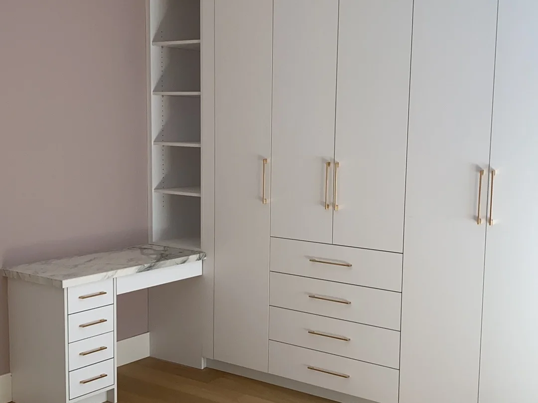 Completed home office combining a compact desk and full-height wardrobe storage.