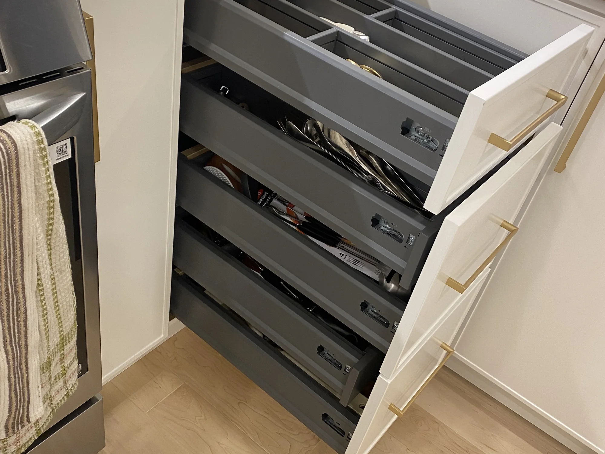 Installed tiered kitchen drawer organizer for utensils and small tools.