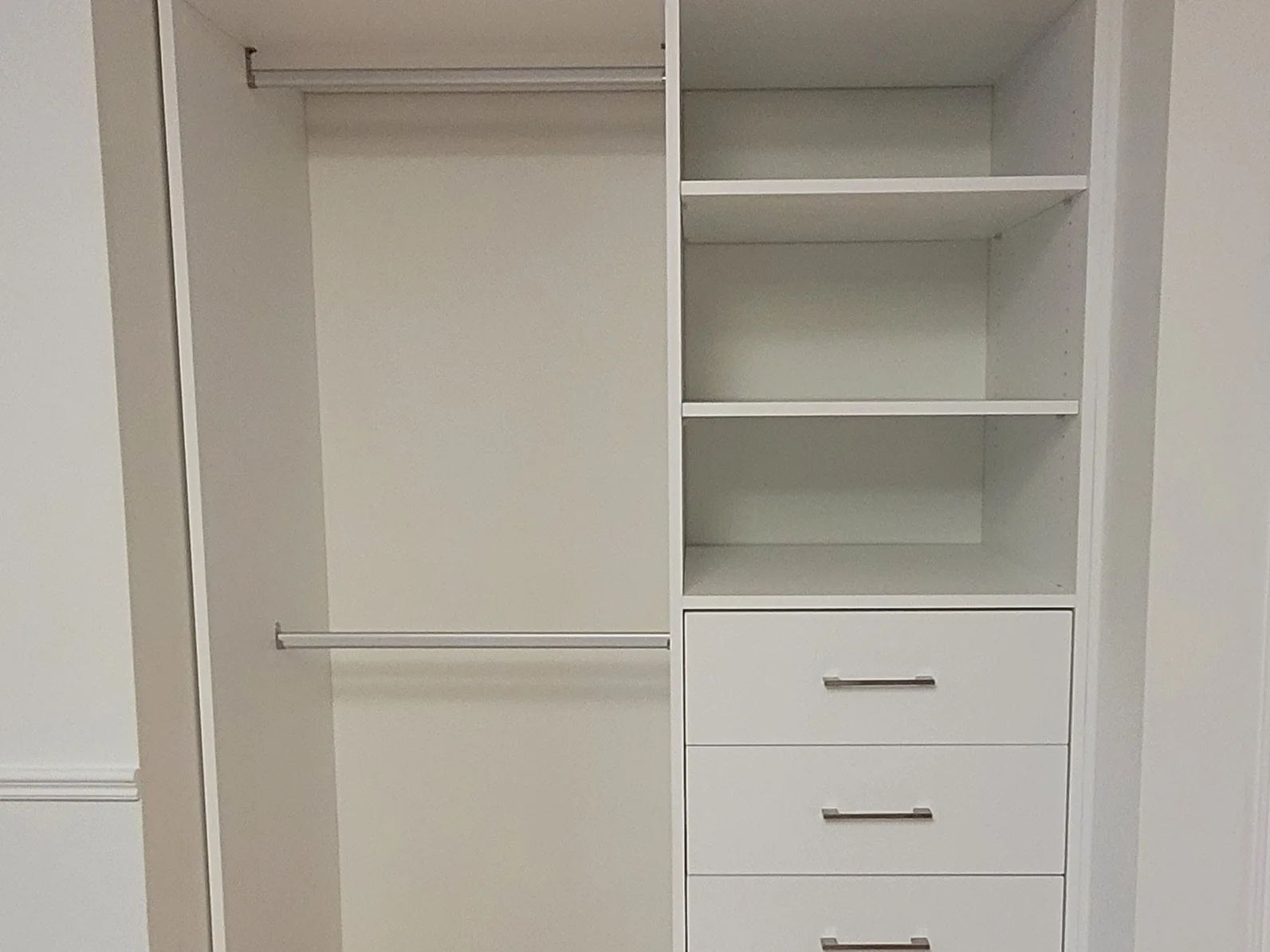 Completed compact reach-in closet with hanging space, shelves, and drawers.