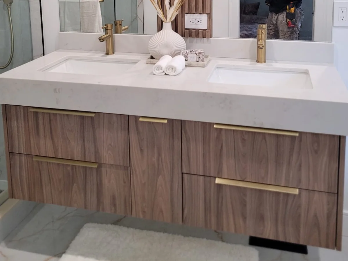 Completed floating wood vanity with integrated drawers and a white counter.