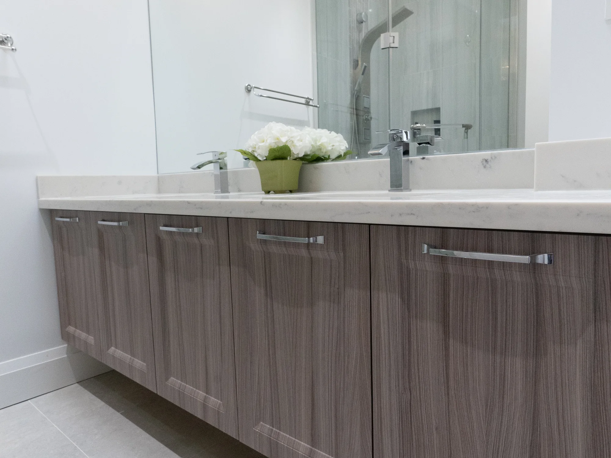Completed wood double vanity with drawers, cabinet doors, and a stone counter.
