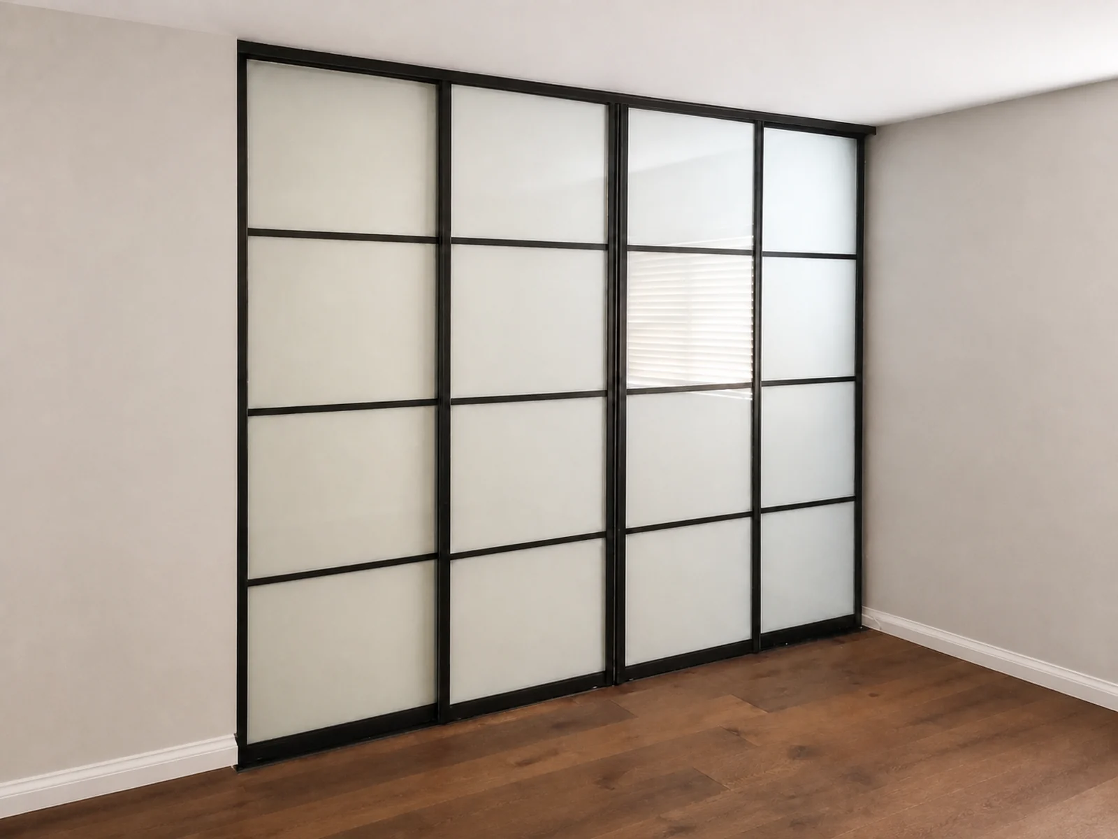 Four black-framed frosted glass closet doors shown across the closed opening.
