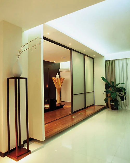 Interior sliding room divider with dark frame panels separating a living area.